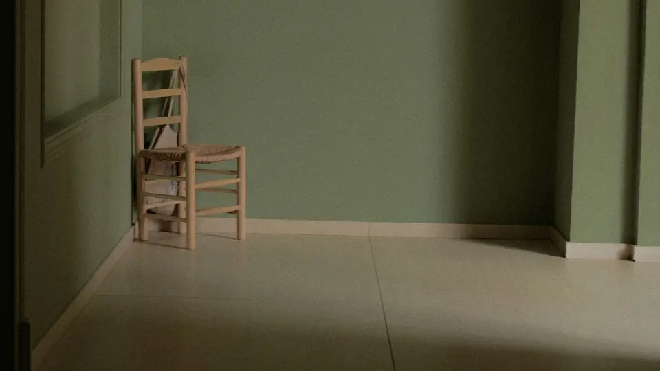 Person sitting cross-legged in silent meditation inside sunlit room free of screens