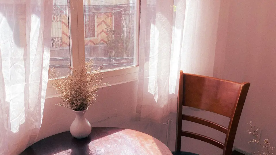 Sun-drenched living room with zero visual clutter, single reading chair, and open view