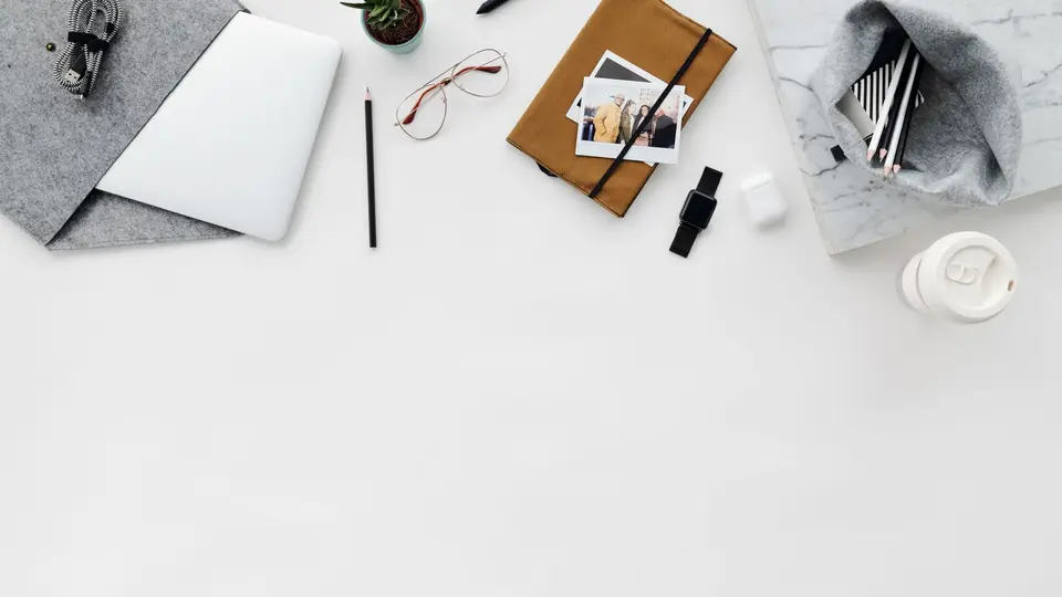 Minimalist ceramic mug, linen notebook, and brass pen on textured concrete desk