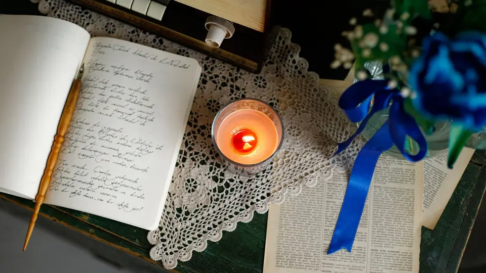 Leather journal open on rustic wooden table with handwritten philosophical reflections