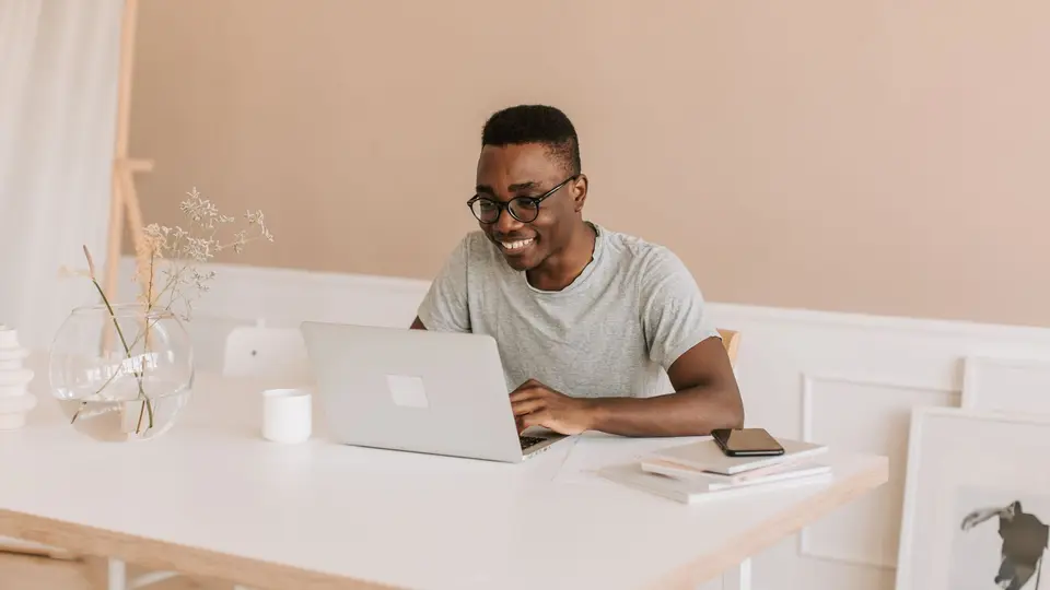 Solo non-technical founder smiling while working from bright aesthetic coffee shop