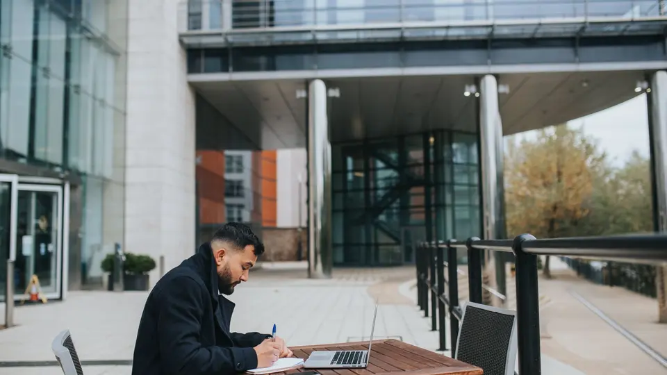 Smiling indie founder working remotely from scenic mountain cabin terrace