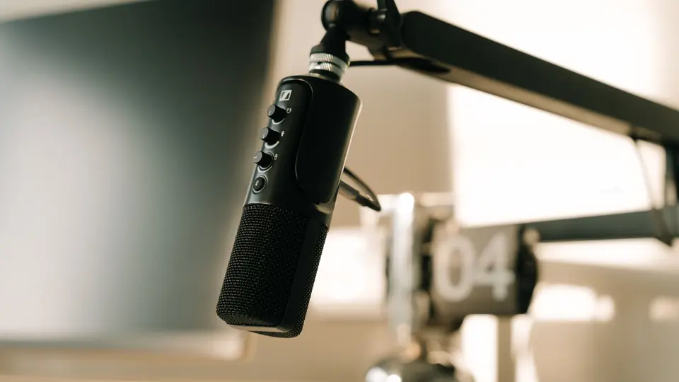 Professional broadcast microphone on boom arm with glowing 'ON AIR' indicator
