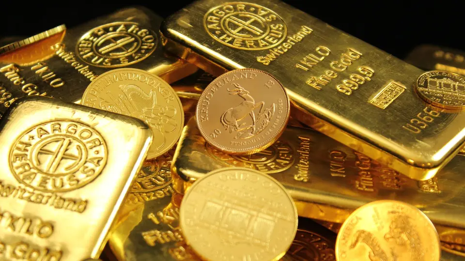 Secure bank vault interior stacked with heavy solid gold bullion bars reflecting warm light