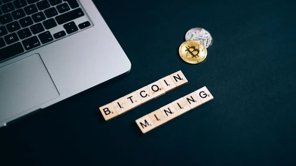 Physical cryptocurrency coin hardware cold-storage wallet illuminated beside ledger