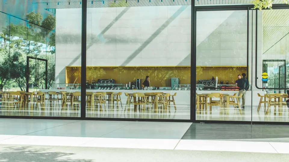 Open-plan startup bullpen with employees working late under exposed industrial pipes
